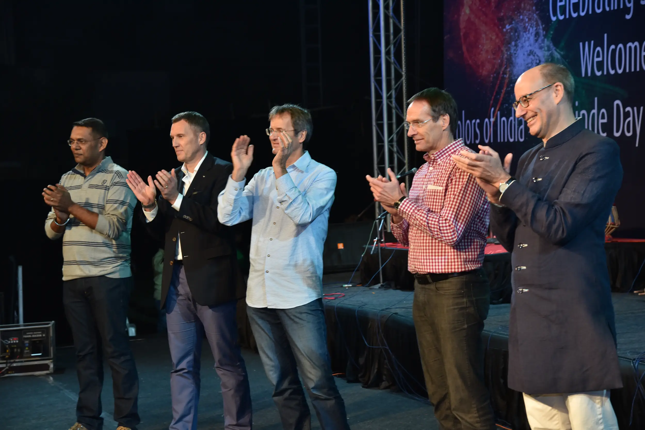 Man and woman speaking on stage at night with blue lighting